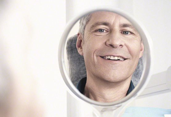 Lächelnder Patient nach Einsatz von Zahnimplantat Zahnimplantate Dortmund